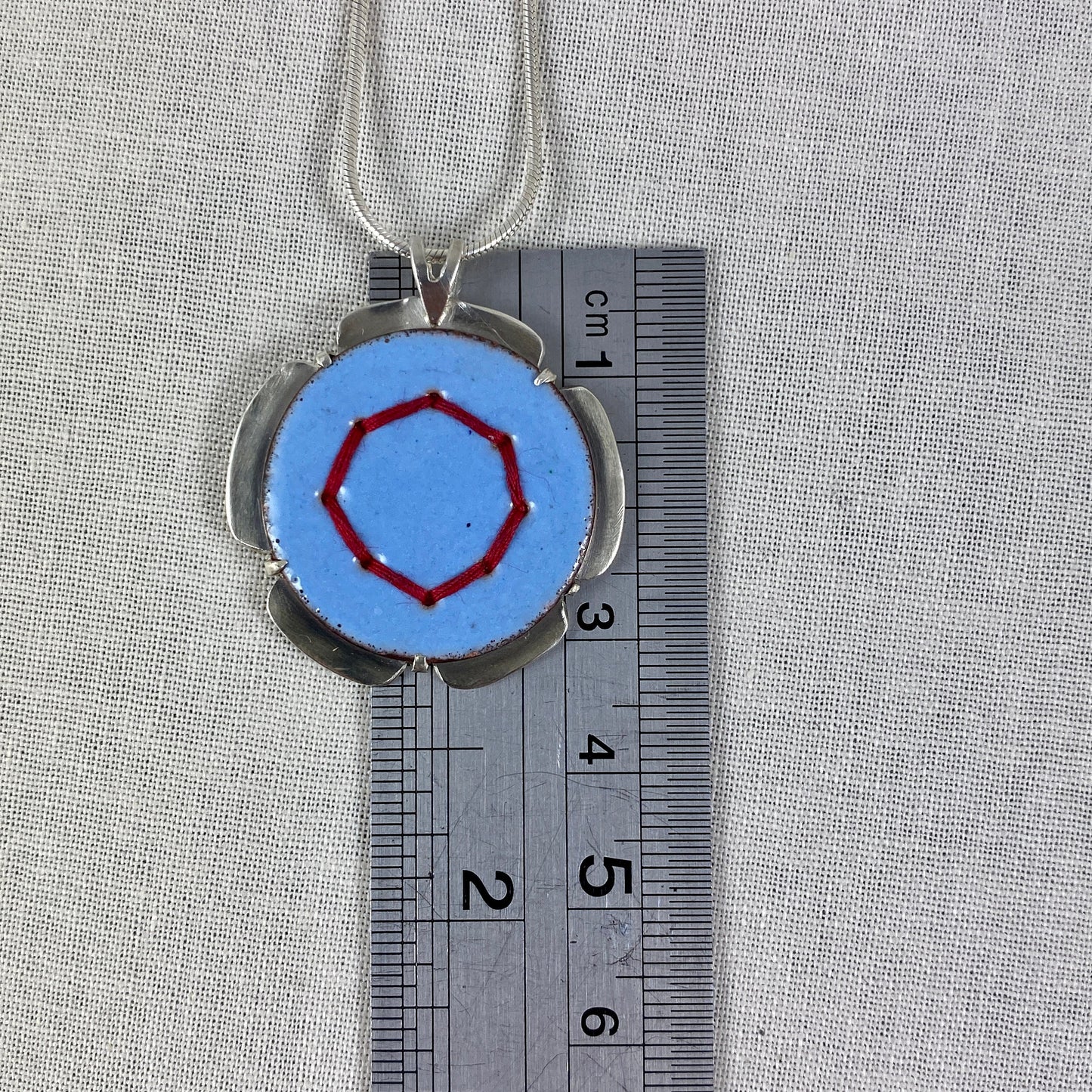 Blue Circle Pendant with Silver and Red Stitches