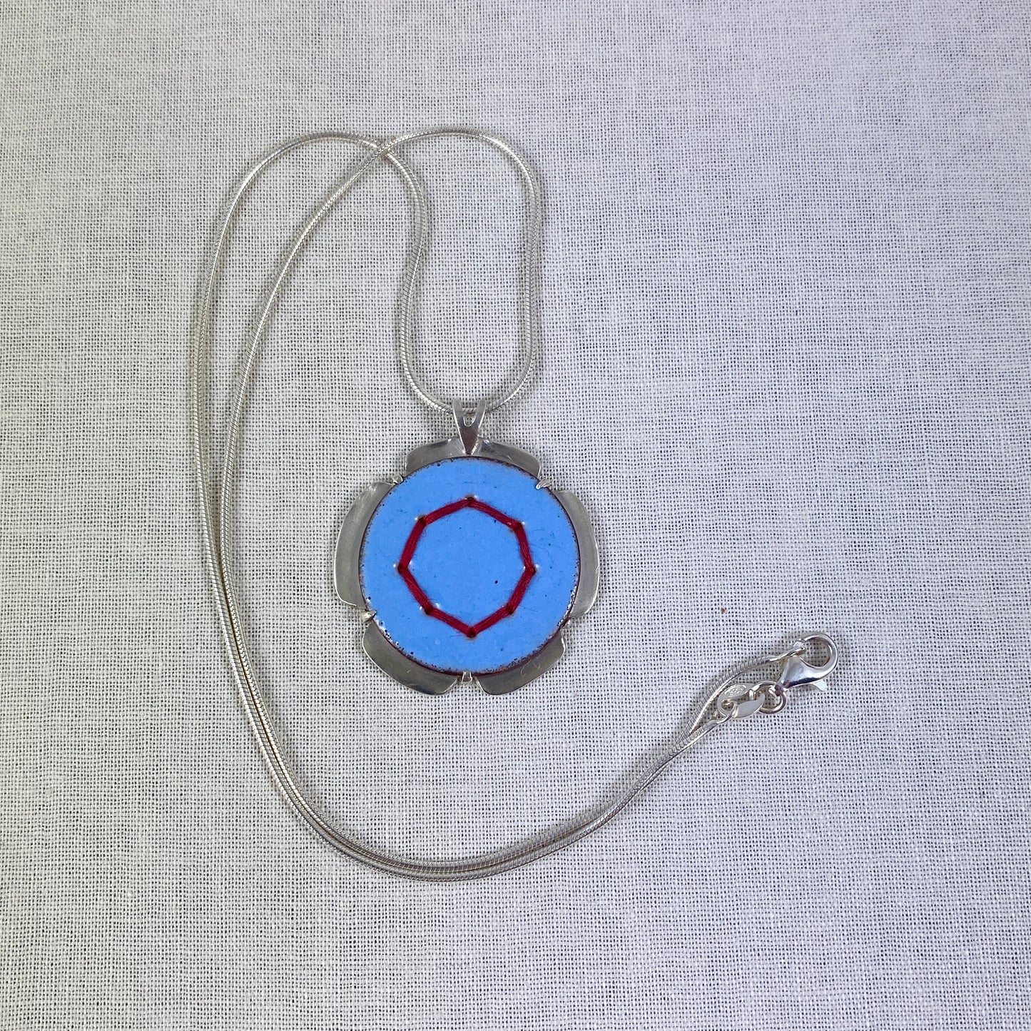 Blue Circle Pendant with Silver and Red Stitches